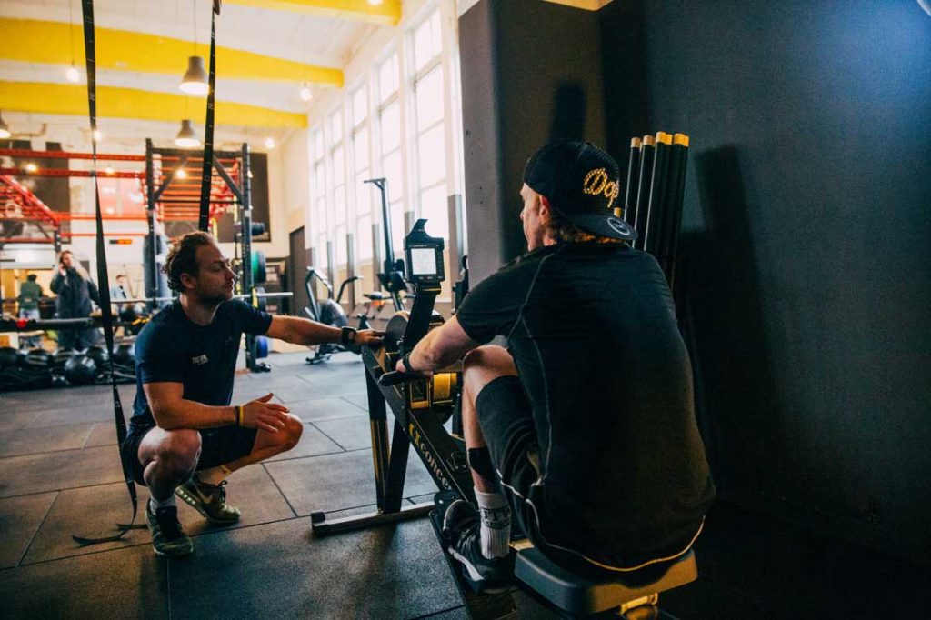 Personal trainer bekijkt sporter tijdens oefening