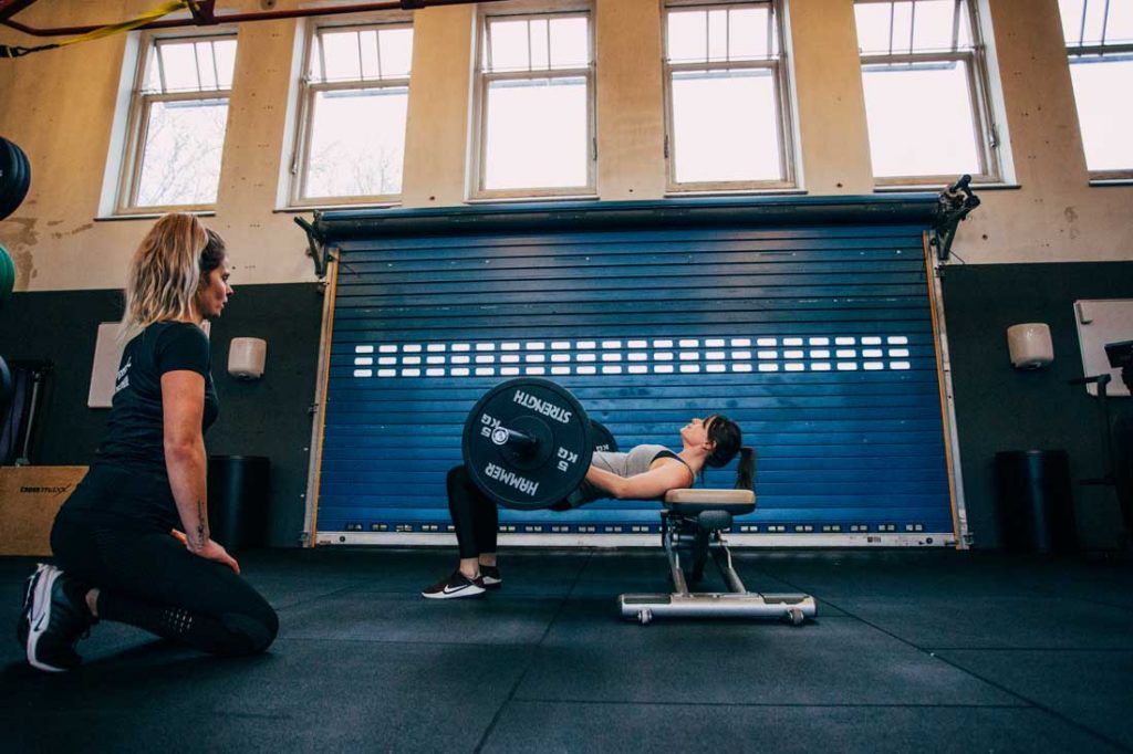 Personal trainer bekijkt sporter tijdens oefening